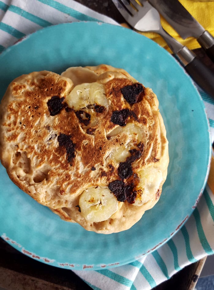 A thick pancake with blueberries and sliced banana baked into it.