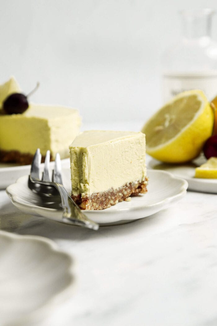 Thick slice of lemon cheesecake on a plate with a fork.