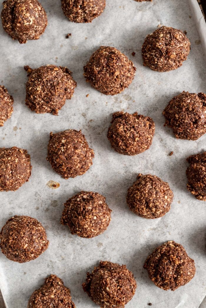 Baked chocolate macaroons on a parchment paper-lined baking tray.