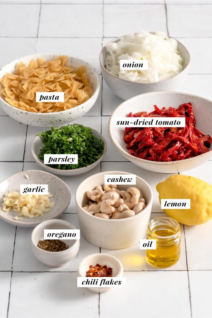 All the ingredients needed for making a sun dried tomato pasta recipe. Each ingredient is labelled with a text layover.
