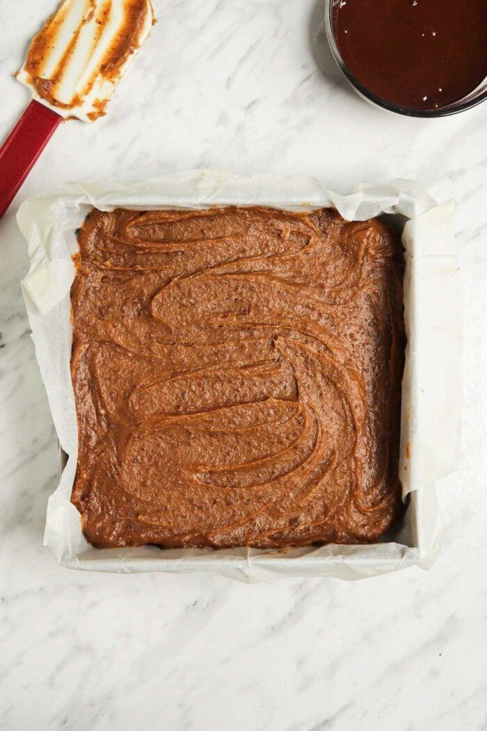 Date caramel spread into an even layer in a square baking pan.